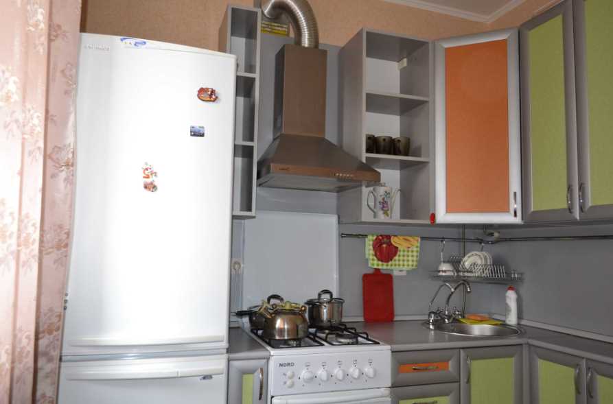 Холодильник рядом с плитой на кухне